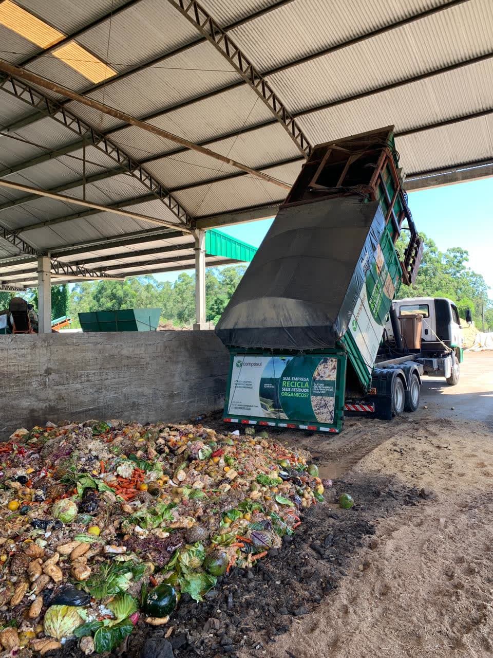A Composul truck tipping a load of separated organics; the full truck and load are visible.